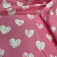 כותנה 250 לבבות לבנים עם קשקוש לבן עליהם על רקע ורוד מסטיק בהיר